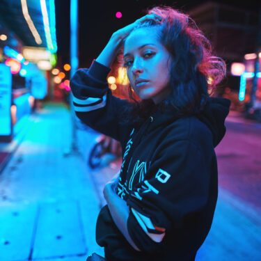 Neon close up portrait of young woman wear hoodie. night city street shot Neon close up portrait of young beautiful woman wear hoodie. night city street shot